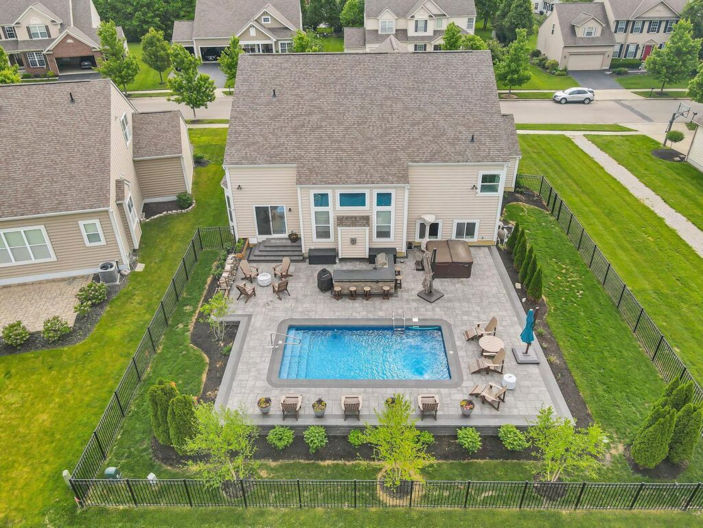 Flores Custom Built Pools #5 - Flores Landscapes Custom built pool with outdoor seating and lush greenery in Central Ohio