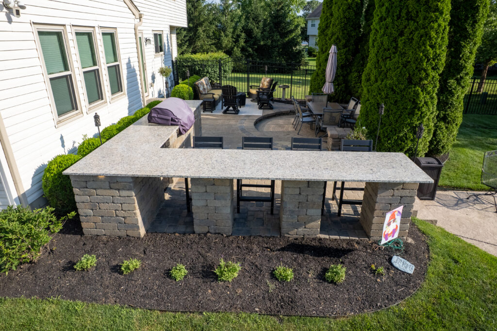 FloresLandscapingBrentBakerOutdoorKitchen-20 1 - Flores Landscapes Beautiful stone outdoor kitchen seating with grill